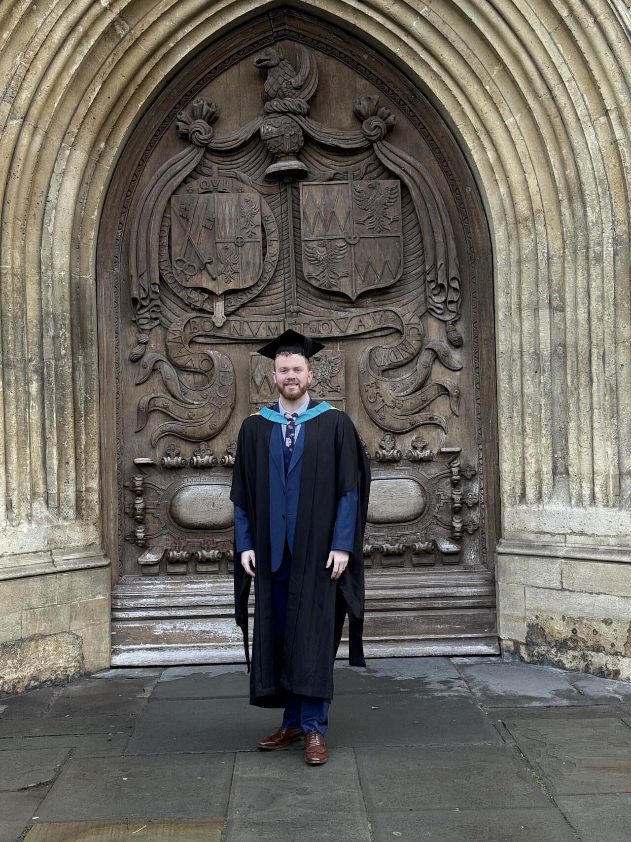 Branden Millward in graduation gown and cap outside Bath Abbey after his AI Master's graduation